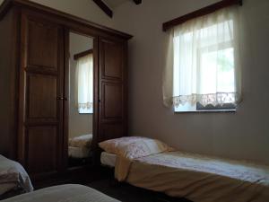 sypialnia z 2 łóżkami, lustrem i oknami w obiekcie Holiday home Cvita w mieście Starigrad-Paklenica