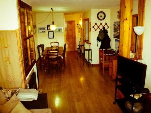 a living room with a table and a dining room at Apartamentos Formigal - admite mascotas in Formigal