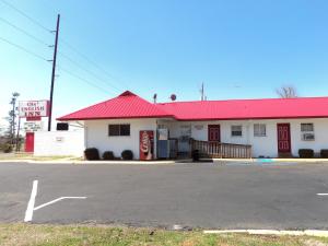 a building with a red roof and a parking lot at Ole English Inn in Tuscaloosa