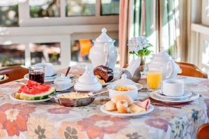 a table with breakfast foods and drinks on it at Pousada Casa Rosa in Canela