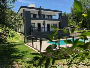 una casa con piscina delante en COMPLEJO AYRES DE MAYU SUMAJ, en Villa Carlos Paz