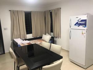 cocina con mesa negra y nevera blanca en COMPLEJO AYRES DE MAYU SUMAJ, en Villa Carlos Paz