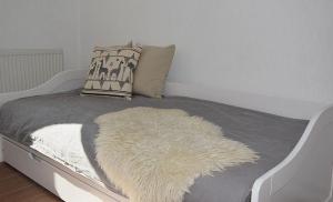 a white bed with a furry rug on it at Moewe in Landkirchen