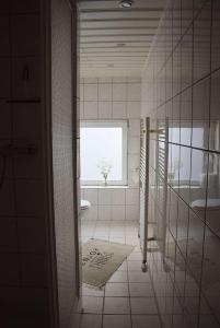 La salle de bains blanche est pourvue d'une fenêtre et d'un lavabo. dans l'établissement Moewe, à Landkirchen