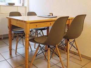 a wooden table with four chairs around it at Moewe in Landkirchen