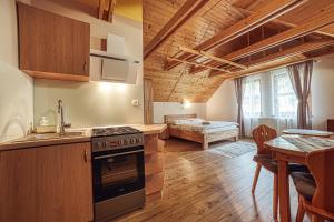 eine Küche und ein Wohnzimmer mit einem Tisch und einem Bett in der Unterkunft ZET - Penzion & Wellness in Vyšné Ružbachy