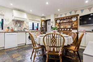 a kitchen and dining room with a table and chairs at The Willows in Christchurch