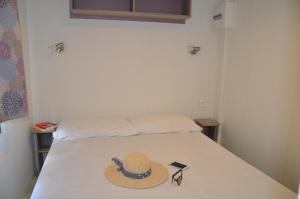 a hat and sunglasses sitting on a bed at Happy Camp mobile homes in Camping Amadria Park Camping Trogir in Seget Vranjica +29 photos