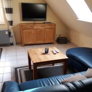 a living room with a couch and a table and a tv at Ferienwohnung-Achtern-Diek in Petersdorf auf Fehmarn