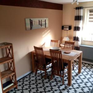 a dining room with a wooden table and chairs at Ferienwohnung-Achtern-Diek in Petersdorf auf Fehmarn