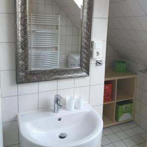a bathroom with a white sink and a mirror at Ferienwohnung-Achtern-Diek in Petersdorf auf Fehmarn