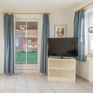 a living room with a tv and a window at Ferienwohnung-Kuestennaehe in Wenkendorf