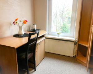 a kitchen with a table with a vase of flowers on it at Alanta "Easy Kaunas" in Kaunas