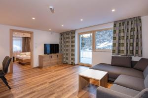 a living room with a couch and a tv at Apart Alpenjuwel Sölden in Sölden