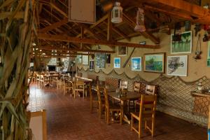 a restaurant with tables and chairs in a room at Pension Sharaiman in Dunavăţu de Jos