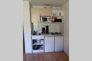 - une petite cuisine avec des appareils électroménagers blancs dans une chambre dans l'établissement Superbe appartement la Foux d'Allos, à La Foux