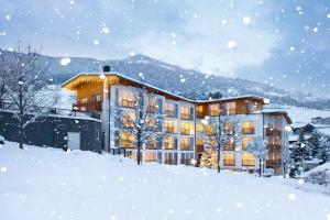 een groot gebouw in de sneeuw met sneeuw bij Hotel Holunderhof in Lienz