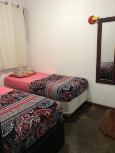 a room with two beds and a mirror at Hostel Icaraí Inn in Niterói