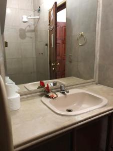 um balcão de casa de banho com um lavatório e um espelho em Hostel Icaraí Inn em Niterói