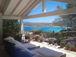 a living room with a view of the water at Domus de Rocas Holiday House in Porto Rotondo