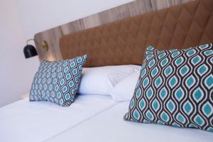 uma cama com duas almofadas em cima em Hotel Presidente 4 sup em Benidorm