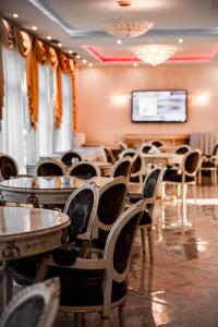 a conference room with tables and chairs and a screen at Hotel Holiday Park in Warsaw