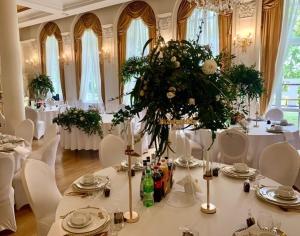 a room with a table with white tables and chairs at Hotel Holiday Park in Warsaw