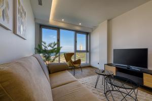 a living room with a couch and a flat screen tv at TH Apartments by Como en Casa in A Coruña