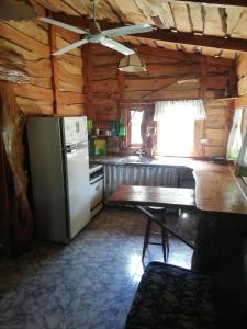 a kitchen with a refrigerator and a table at Cabañas Monje in Tandil