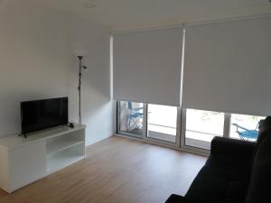 sala de estar con TV de pantalla plana y ventanas grandes. en Welcome Douro, en Cinfães
