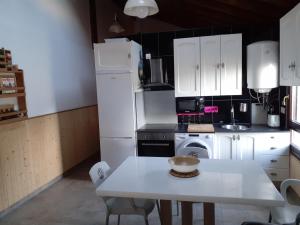 a kitchen with white appliances and a white table at Playa Laga in Ibarrangelu
