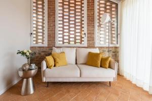 Monteleone dʼOrvietoにあるBorgo Giorgioneの窓付きの客室で、白いソファ(黄色い枕付)