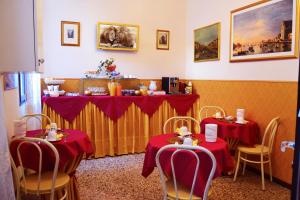 uma sala de jantar com duas mesas com toalha de mesa vermelha em Art Dreams B&B em Veneza