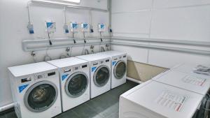 a laundry room with three washing machines in it at München-Riem my room Apartment an der Messe in Munich