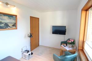 a living room with a tv on a wall at Kapitaenshaus-Lassen-Zimmer-Nes-Puek in Westerland (Sylt)