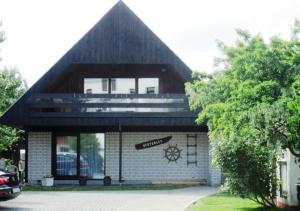 ein Gebäude mit einem Dach mit einem Schild darauf in der Unterkunft Kapitänshaus Lassen - Zimmer Nes Pük in Westerland