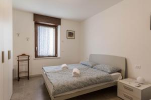 a bedroom with a bed with two pillows and a window at Casa Balansina in Brenzone sul Garda