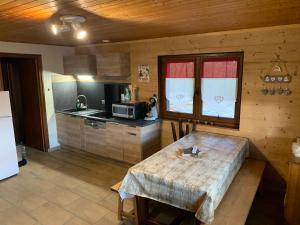 a kitchen with a table in a room with a refrigerator at APPARTEMENT PLEIN SUD AUX SAISIES n3 in Les Saisies