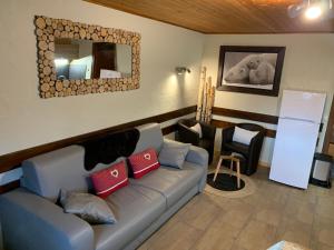a living room with a couch and a mirror at APPARTEMENT PLEIN SUD AUX SAISIES n3 in Les Saisies +29 photos
