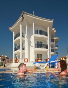 three people in the swimming pool in front of a building at Nevada Hotel & Spa in Fethiye