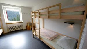 a bunk bed in a room with a window at Valbella-Lenzerheide Youth Hostel in Lenzerheide