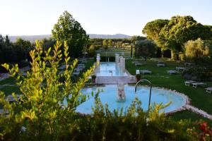 a swimming pool in a park with a fountain at Hotel Salus Terme - Adults Only in Viterbo
