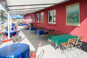 ein rotes Gebäude mit Tischen, Stühlen und einem grünen Tisch in der Unterkunft Ferienwohnung für 2 Erwachsene auf Rügen in Groß Banzelvitz