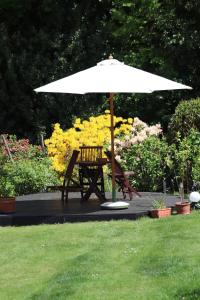 a table and chair under an umbrella in a garden at Ferienwohnung Im Waldwinkel in Stadthagen