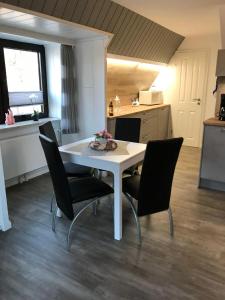 una mesa blanca y sillas en una cocina en Andrea-OG, en Büsum