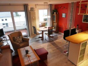 a living room with a table and chairs and red walls at Sonnenschein in Sassnitz