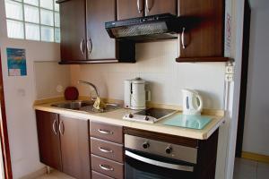 eine kleine Küche mit Spüle und Mikrowelle in der Unterkunft Casa Anna, cerca la playa in Arona + 7 Fotos