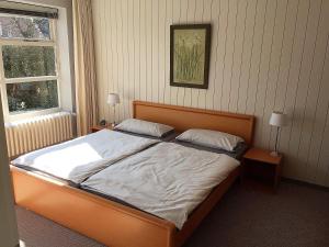 a bedroom with a large bed with white sheets at Haus-Muehlenpark in Wyk auf Föhr