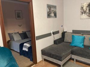 een slaapkamer met een bed, een bank en een spiegel bij Apartment Artynova 29 in Vinnytsya