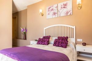 una camera da letto con un letto con cuscini viola di Casa Quintana - Apartamento Carla a Tijarafe